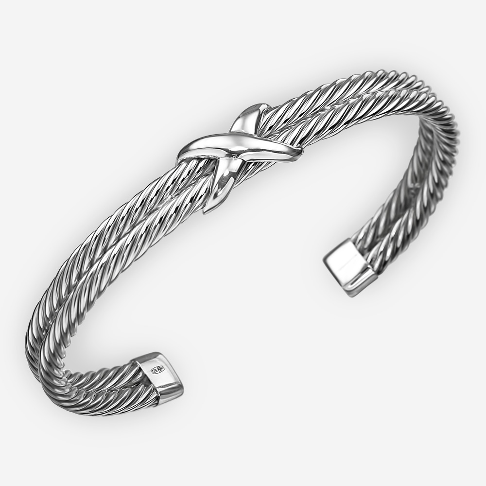 Brazalete de cable trenzado de plata fina. Se compone de dos brazaletes con patrón de cable retorcido y un punto focal cruzado.