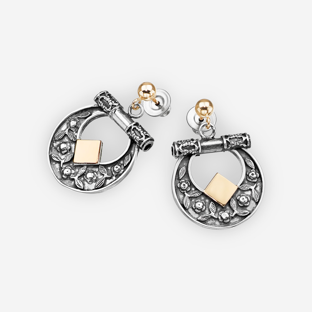 Aretes con diseños florales hechos de plata oxidada y oro de 14k.